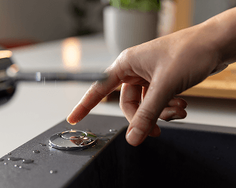 Ação do acionamento do triturador por botão próximo à pia